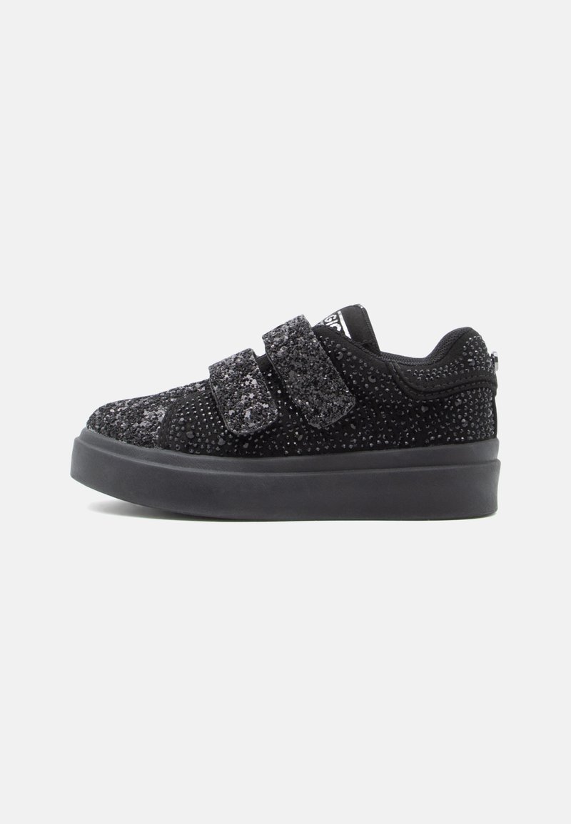 Sneaker nera bassa con suola spessa, ricoperta di piccoli chiodini luccicanti, dotata di due ampie fasce in velcro per la chiusura.