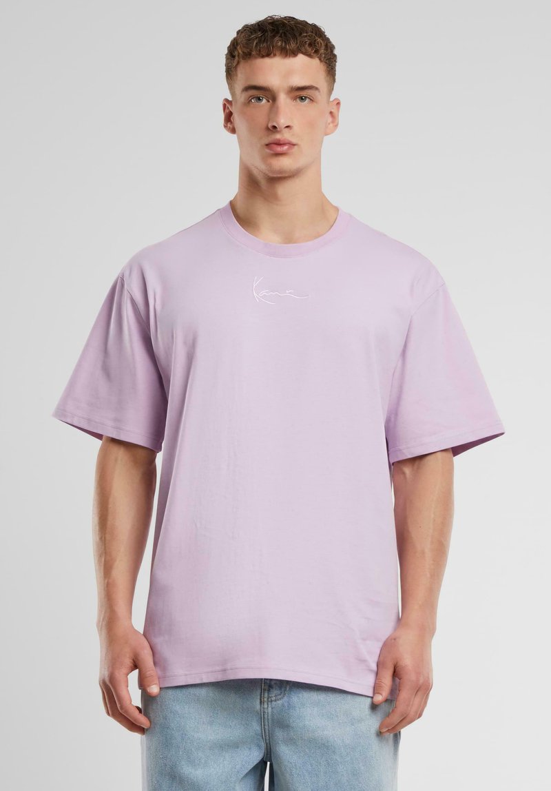 Light purple cotton t-shirt with a crew neck, short sleeves, and a white logo design on the chest. Loose fit and soft texture.