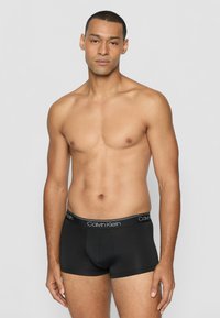 Schwarze Boxershorts mit einem elastischen Bund mit Markenschriftzug. Hergestellt aus weichem, dehnbarem Stoff. Verfügt über einen konturierten Beutel und eine enge Passform.