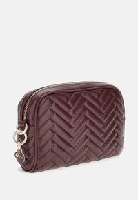 Pochette in pelle testurizzata color bordeaux con motivo a spina di pesce intrecciato, hardware color oro e chiusura con zip, dotata di un portachiavi decorativo.