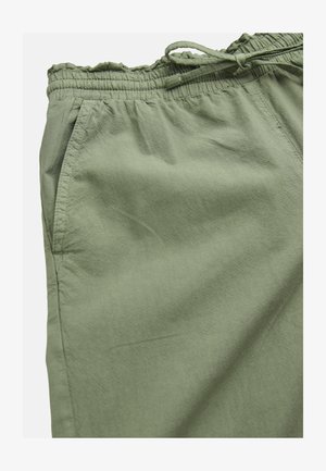 Nahaufnahme von olivgrünen Hosen mit elastischem Bund, Kordelzug und sichtbarer Seitentasche.