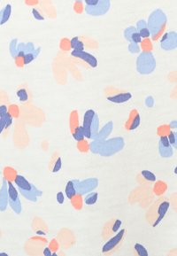 Tejido floral en colores pastel: rosa, azul y blanco. Presenta formas de flores abstractas y pequeños pétalos, con una apariencia suave y texturizada.