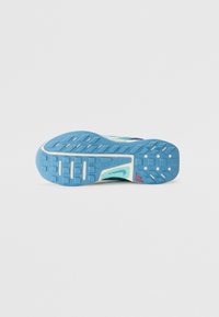 Semelle de chaussure de trail Nike bleu et blanc avec un profil texturé et un petit logo rouge sur fond blanc.