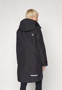 Svart vanntett parkas med hette, med en liten hvit logo på baksiden, justerbare mansjetter og reflekterende detaljer nær nederkanten.