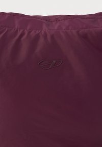 Tejido de pluma color burdeos con una textura suave. Presenta un logo minimalista estampado en la superficie, diseñado para proporcionar calor y comodidad.