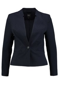 Tmavě modrý blazer s texturou teček, s jedním knoflíkem, úzkým střihem a strukturálními klopami. Dlouhé rukávy sahají až k zápěstí.