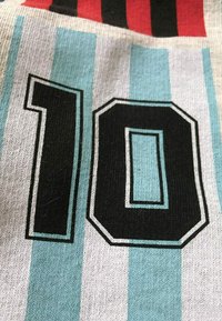 Katoen jersey met verticale strepen in lichtblauw, grijs en rood. Het nummer "10" in zwart met een witte rand is prominent weergegeven.