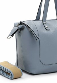 Blauwe leren handtas met een gestructureerd oppervlak, bovenhandvatten en zwarte accentstiksels. Inclusief een gerolde beige schouderriem naast de tas.