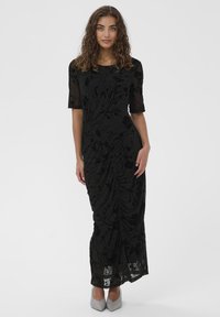 Čierne šaty s polovičnými rukávmi, s naťahovanými detailmi, kvetinový vzor v priesvitnom materiáli, dlhý strih, kombinované so svetlošedými opätkami.