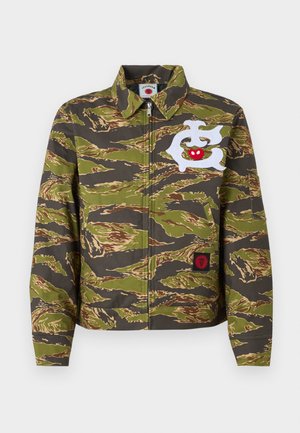 Veste à motif camouflage en vert et marron avec des accents brodés blancs et rouges, dotée d'un col et d'une fermeture éclair.