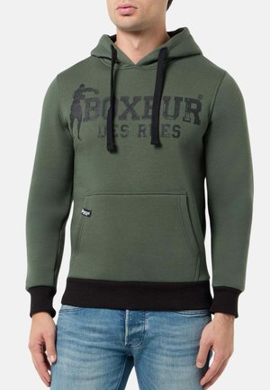 Felpa verde con cappuccio realizzata in misto cotone, caratterizzata da una stampa grafica nera e da un cordino. Include una tasca frontale a marsupio e polsini a coste.