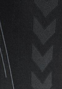 Svart atletisk tyg med en strukturerad design med diagonala linjer och chevronmönster. Slät yta med kontrasterande mörkare accenter.