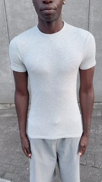 Gray fitted t-shirt made of soft cotton fabric, featuring short sleeves and a crew neckline, paired with light gray relaxed trousers.