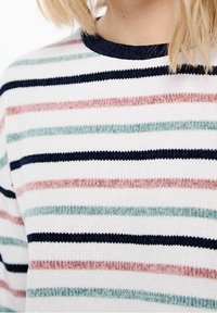 Sweter w paski z dzianiny w kolorze granatowym, różowym, zielonym i białym, z poziomymi liniami. Materiał ma miękką fakturę i ribbowe wykończenie dekoltu.