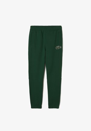 Ciemnozielone dresy z elastycznym pasem i mankietami, bocznymi kieszeniami oraz małym wyszywanym logiem krokodyla na prawej udzie.