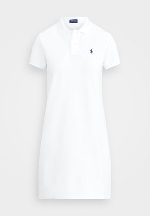 Hvit polo-kjole laget av bomull, med kragehals, korte ermer og en liten brodert logo i blått på venstre bryst.