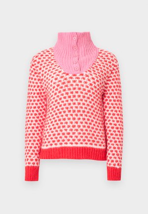 Kötött pulóver rózsaszín magas gallérral, piros-fehér csillagminta, hosszú ujjakkal, bordázott szegéllyel és mandzsettákkal. Elöl gombos részletek láthatók.