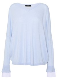 Maglione oversize azzurro chiaro con scollatura a V, maniche ampie e polsini bianchi plissettati. Realizzato in materiale morbido, presenta una vestibilità rilassata.