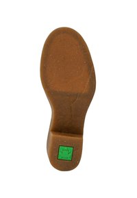 Suela de zapato de goma marrón con superficie texturada; presenta un logo de rana verde sobre una base cuadrada. Forma lisa con bordes redondeados y sin patrones visibles.