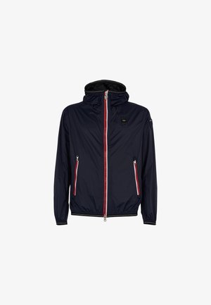 Giubbotto in nylon blu navy con chiusura a zip, strisce decorative rosse e bianche, polsini elasticizzati e cappuccio. Presenta due tasche laterali con zip.