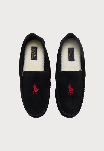 Ζευγάρι μαύρα παντόφλες slip-on με κόκκινο λογότυπο Polo Ralph Lauren και λευκή επένδυση από φλίς, φτιαγμένα από πάνω σε απλό φόντο.