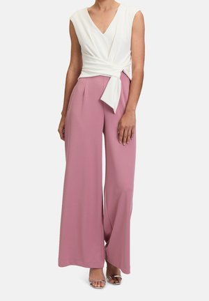 Jasnoróżowy kombinezon o szerokich nogawkach z białym topem w stylu kopertowym, z dekoltem w kształcie litery V i zawiązanym detalem w talii. Gładka tekstura materiału.