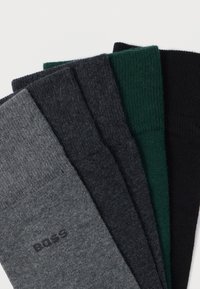 Πέντε ζευγάρια κάλτσες σε διάφορα χρώματα: ανοιχτό γκρι, σκούρο γκρι, σκούρο πράσινο και μαύρο. Το ύφασμα έχει ραβδώσεις και μαλακή υφή. Λογότυπο Boss στην γκρι κάλτσα.