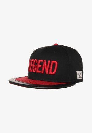 Czarna i czerwona czapka typu snapback z dużym czerwonym napisem „LEGEND” wyszytym z przodu oraz małą metką „Cayler & Sons” po boku.