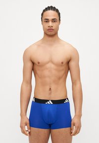 Μπλε μποξεράκια με μαύρη ζώνη που διαθέτει τρεις λευκές ρίγες. Λείο υλικό και εφαρμοστό σχέδιο.