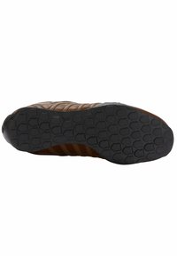 Bruine sneakerzool met een gestructureerde zwarte rubberen onderkant. Kenmerkt een geometrisch patroon voor grip en ribbeldetails aan de zijkant.
