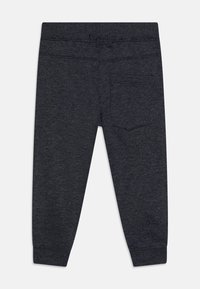 Donkergrijze joggers van zachte stof, met een elastische tailleband, taps toelopende boorden en een enkele achterzak met een subtiele stiknaad.