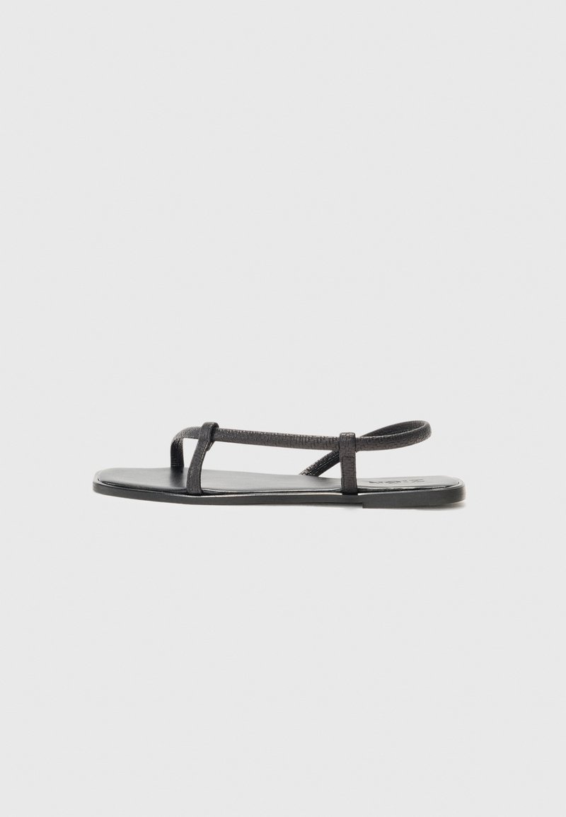 Zwarte platte sandalen met dunne, gestructureerde banden en een minimalistisch ontwerp. De zool is glad en de algemene vorm is slank en ingetogen.