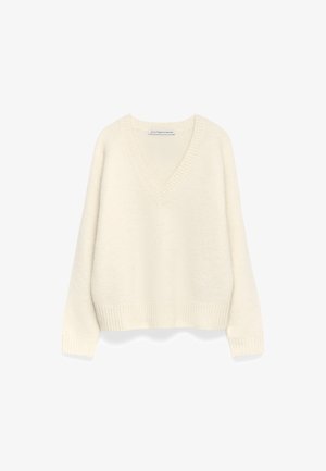 Pull en V crème en tissu doux et texturé. Présente des poignets et un ourlet côtelés, avec une coupe décontractée et oversized.