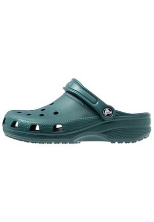 Turkusowy chodak na wsuwkę z otworami wentylacyjnymi, teksturowaną podeszwą i regulowanym paskiem na pięcie z okrągłym logo na białym tle.