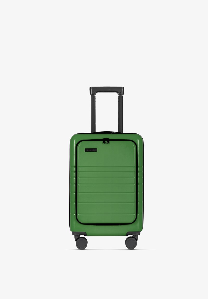 Groene harde koffer met horizontale ribbels, zwarte accenten, uitschuifbare handgreep en vier wielen. Compact en rechthoekig ontwerp.