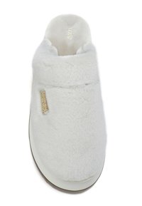 Pantoufle en fausse fourrure blanche avec un bout arrondi, un col rembourré et une étiquette dorée sur le côté. Texture douce et design facile à enfiler.