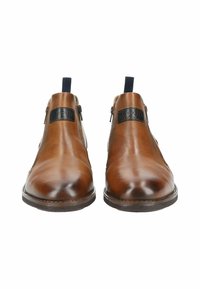 Botas de tobillo de cuero marrón con textura suave, cremalleras laterales, acentos de tela azul y un parche negro con el logo. Diseño clásico y elegante.