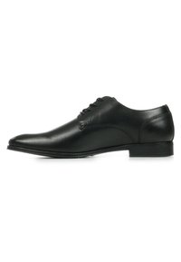 Zwarte leren dresschoenen met een gladde afwerking, ronde neus en lage hak. Voorzien van een vetersysteem met dunne oogjes en minimale stikdetails.