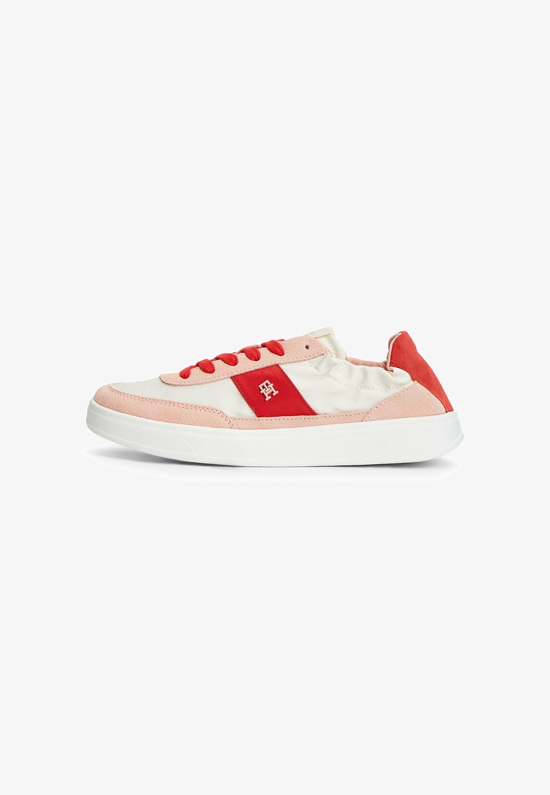Baskets basses avec semelle blanche, tige crème, panneau latéral rouge et lacets, et détails en daim rose, vues de côté extérieur.