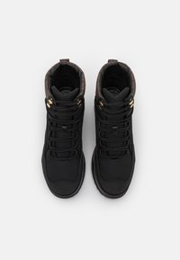 Bottes de randonnée noires avec un col rembourré marron, dotées d'œillets dorés, de lacets texturés et d'une semelle en caoutchouc durable. Tige en textile lisse.