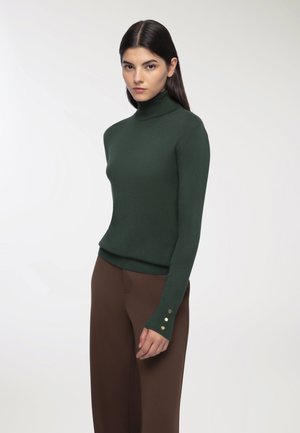 Maglione dolcevita verde scuro con maniche lunghe e fregi dorati ai polsini, realizzato in un tessuto morbido e leggero.