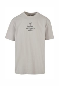 Light gray cotton t-shirt with a crew neck, featuring black text that reads "innocent until proven guilty" and a dove graphic above.