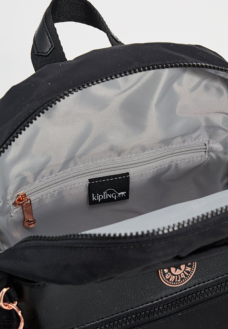 Zaino in tessuto nero con interno argentato, dotato di una tasca con zip e un'etichetta con il logo Kipling. Dettagli includono una zip pull in oro rosa.
