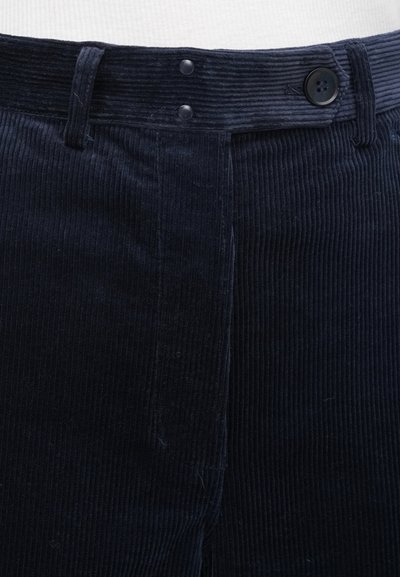 Tumši zili kordurova auduma bikses ar riboto faktūru, divām pogām jostas vietā un klasisku piegriezumu.