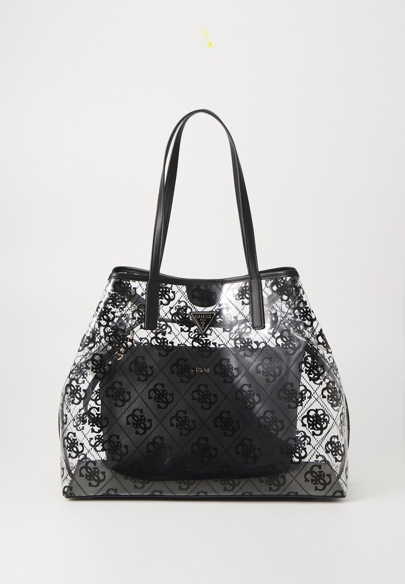 Sac fourre-tout noir et transparent avec un design à motifs, doté de deux poignées noires, d'un accent de logo et d'une forme structurée.