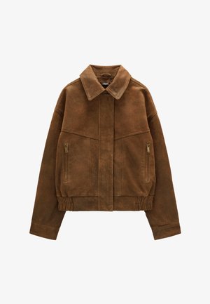 Brązowa zamszowa kurtka z kołnierzem, przednimi kieszeniami na zamek, elastycznym pasem i przodem na guziki, ułożona płasko na białym tle.