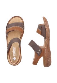 Brown leather sandals featuring dual straps, stitched accents, a rounded toe, and a textured sole for grip. Rieker branding visible.