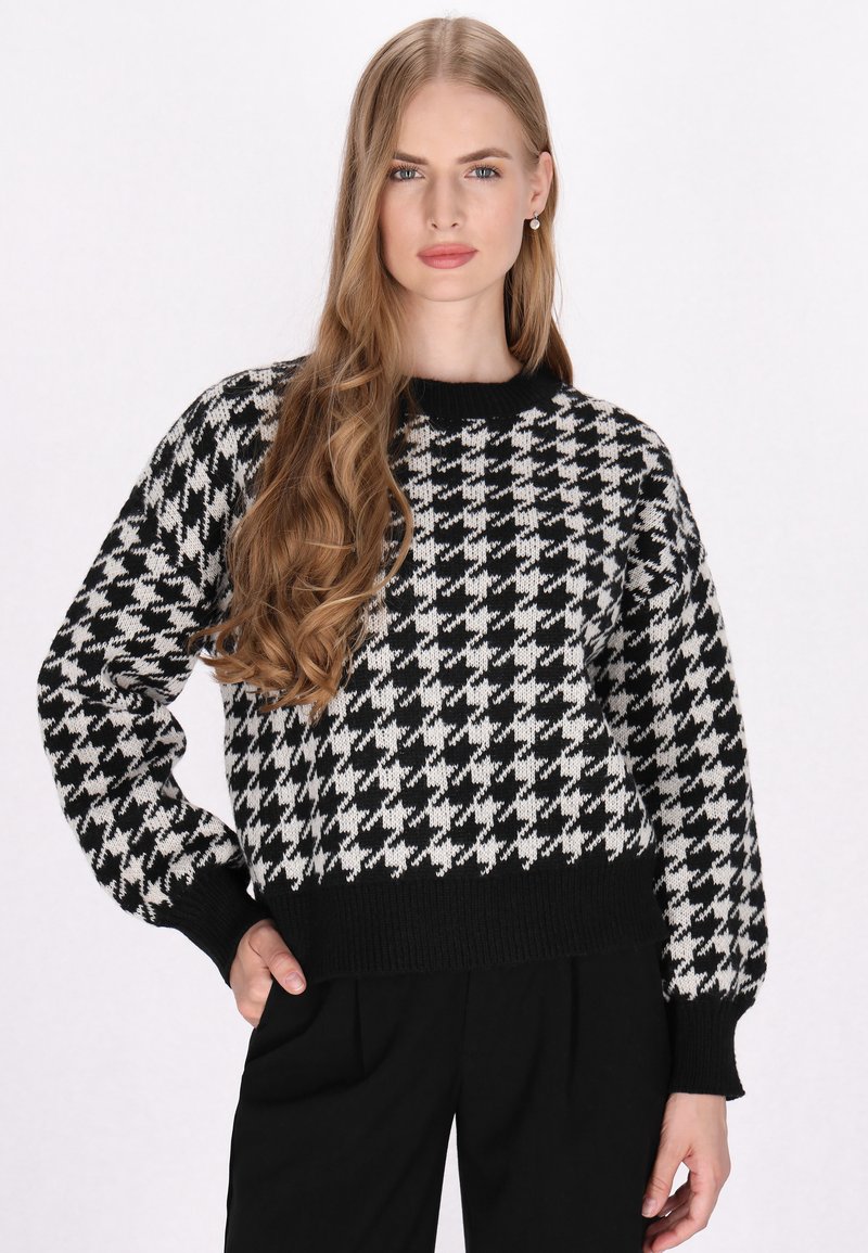Zwart-wit houndstooth-patroon cropped sweater met lange mouwen en een ribgebreide halslijn en zoom. Gemaakt van een zacht breimateriaal.