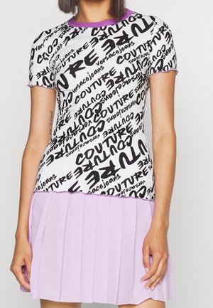 Short-sleeve white top with black scattered text print and purple trim, paired with a pleated light purple skirt.