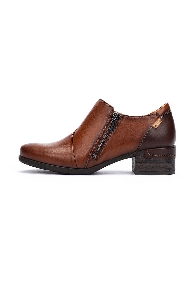 Des bottines en cuir marron présentent une fermeture éclair sur le côté, un bout arrondi et un petit talon carré. Le design intègre des textures contrastantes.